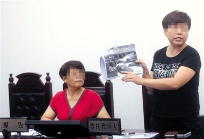 法庭上，原告方出示刻有自己名字墓碑的图片。